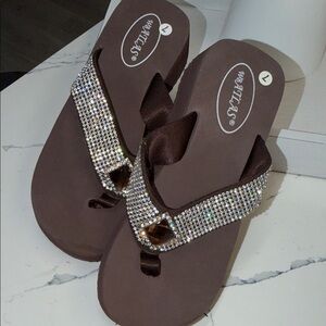 WB Atlas, characterized by their brown foam wedge soles and wide, SOLD
